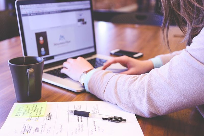 Woman researching SoFi and Earnest rates on laptop