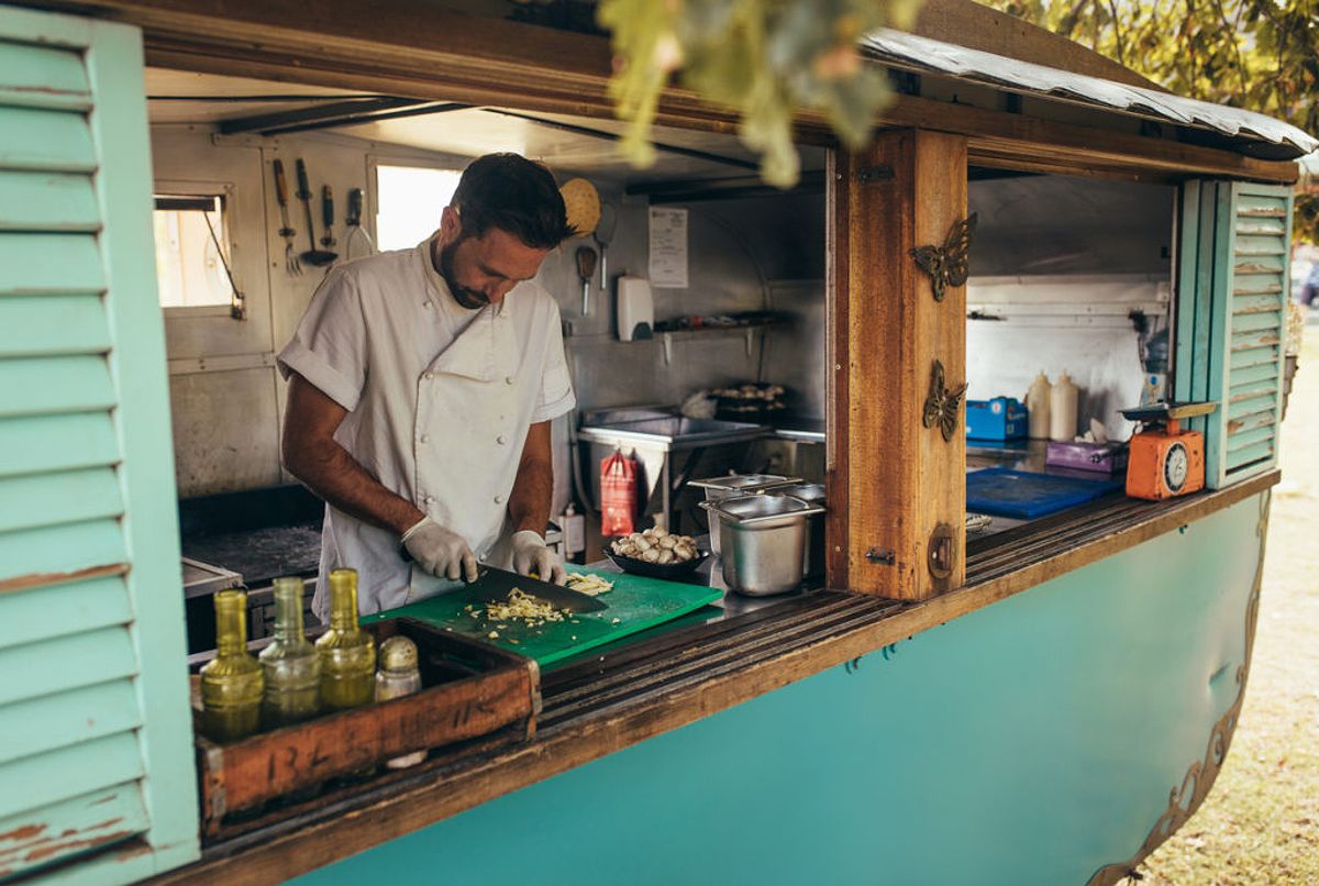 Small business owner chopping vegetables after expanding his operation with a small business loan